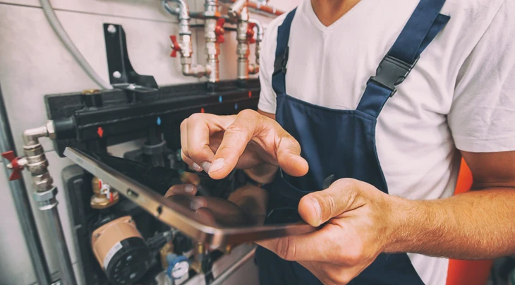 Un artisan électricien-chauffagiste professionnel intervenant dans un intérieur résidentiel, en train d'effectuer une installation ou un diagnostic. La scène doit montrer l'artisan dans une maison ou un appartement, seul ou interagissant avec le client, illustrant clairement son rôle de professionnel polyvalent capable de gérer à la fois l'électricité et le chauffage. L'environnement doit être résidentiel, lumineux et accueillant, montrant la confiance et la proximité avec le client particulier.